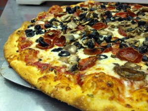 Pino's Pizza out of the oven with mushrooms, pepperoni and black olives