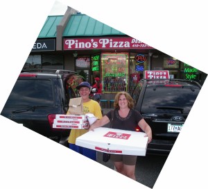 boy carrying pizza and woman carrying XXL pizza from Pino's Pizza