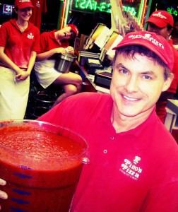 man in Pino's Pizza uniform in ocean city md holding a bucket of pizza sauce