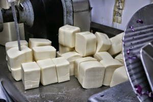 large blocks of mozzarella cheese near slicer